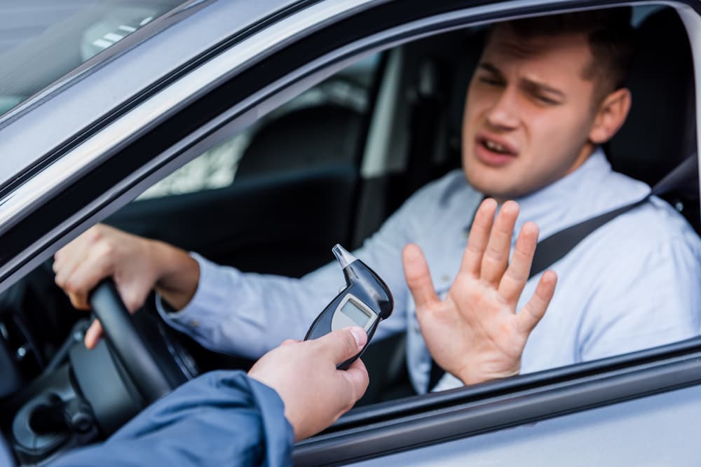 Police officer administering a breathalyzer to a drunk driver in Cleveland, OH and driver is refusing